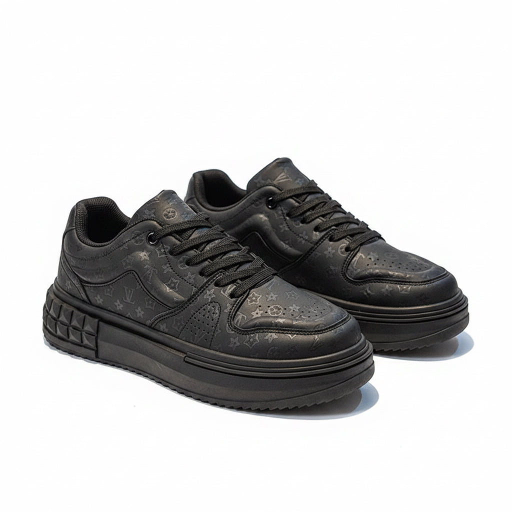 Black sneakers with textured sole on a gray surface