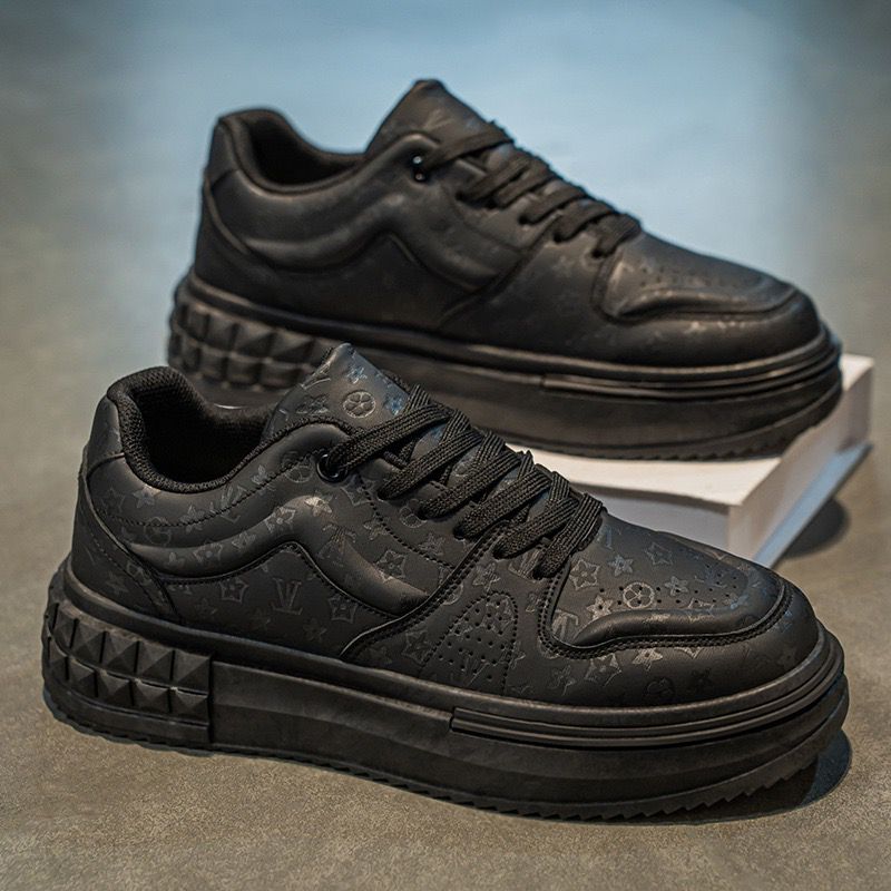 Black sneakers with textured sole on a gray surface