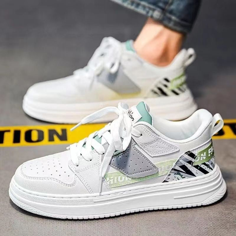 White sneakers with gray and green accents on a gray surface