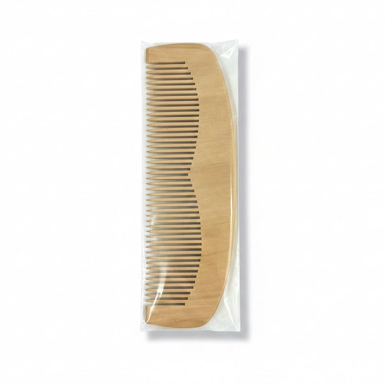 A wooden hair comb packaged in a clear plastic cover with a blue and white product label.
