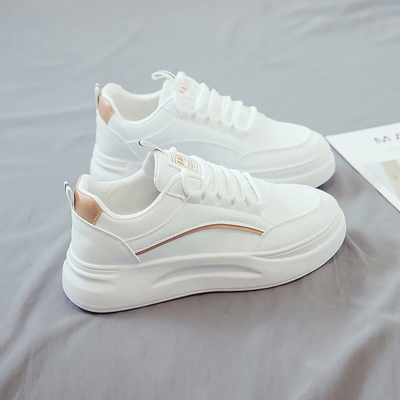 White sneakers on a gray surface with a magazine in the background
