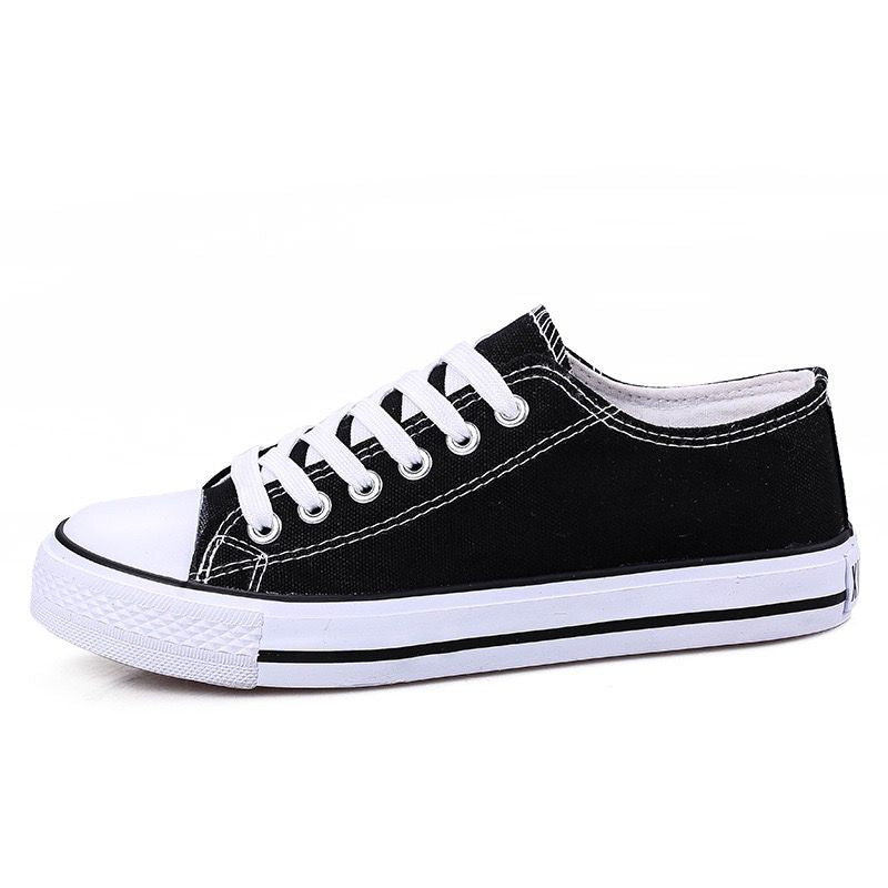 Black canvas shoe with white laces on a white background