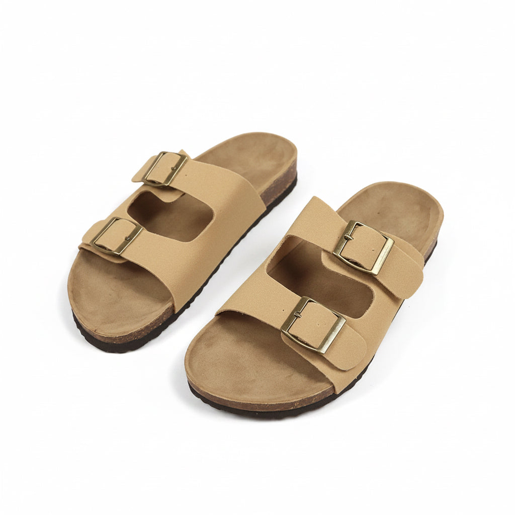 Pair of beige sandals with gold buckles on a beige background