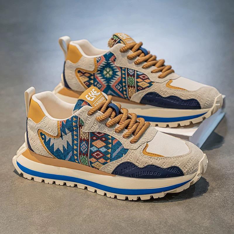 Colorful patterned sneakers on a gray surface with a blue gradient background