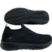 Black slip-on shoes with textured sole on a white background