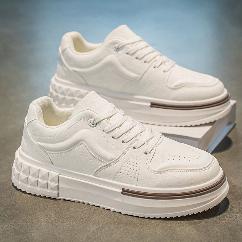 White sneakers with thick soles on a reflective surface