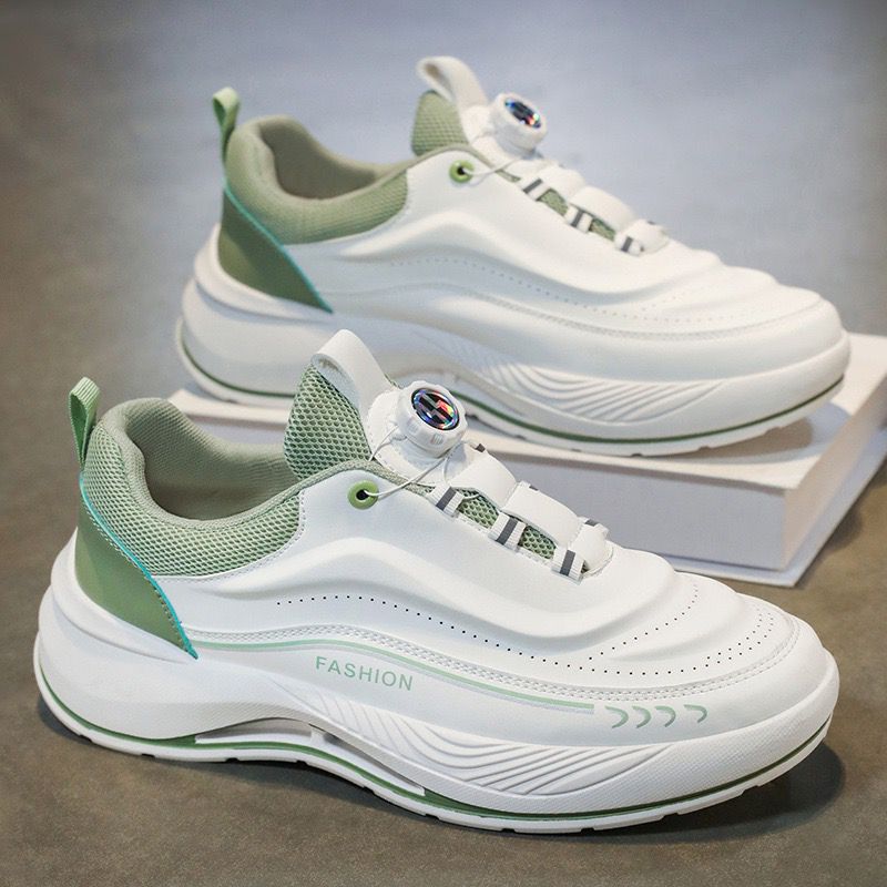 White and green sneakers on a gray surface