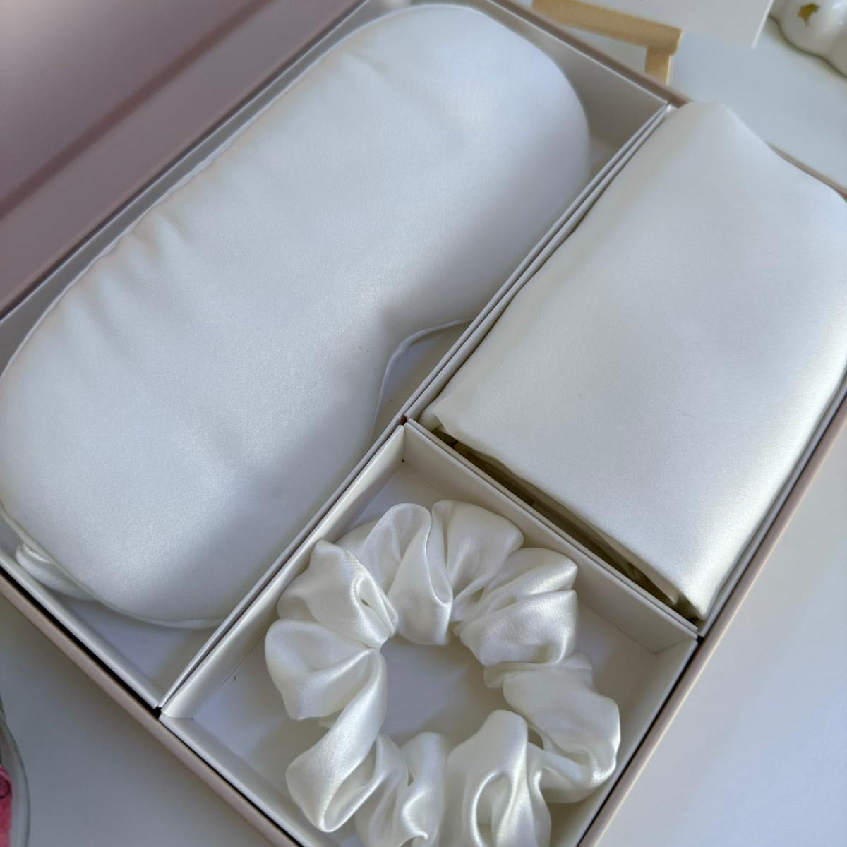 White hair mask and scrunchies in a box with a card on a white background