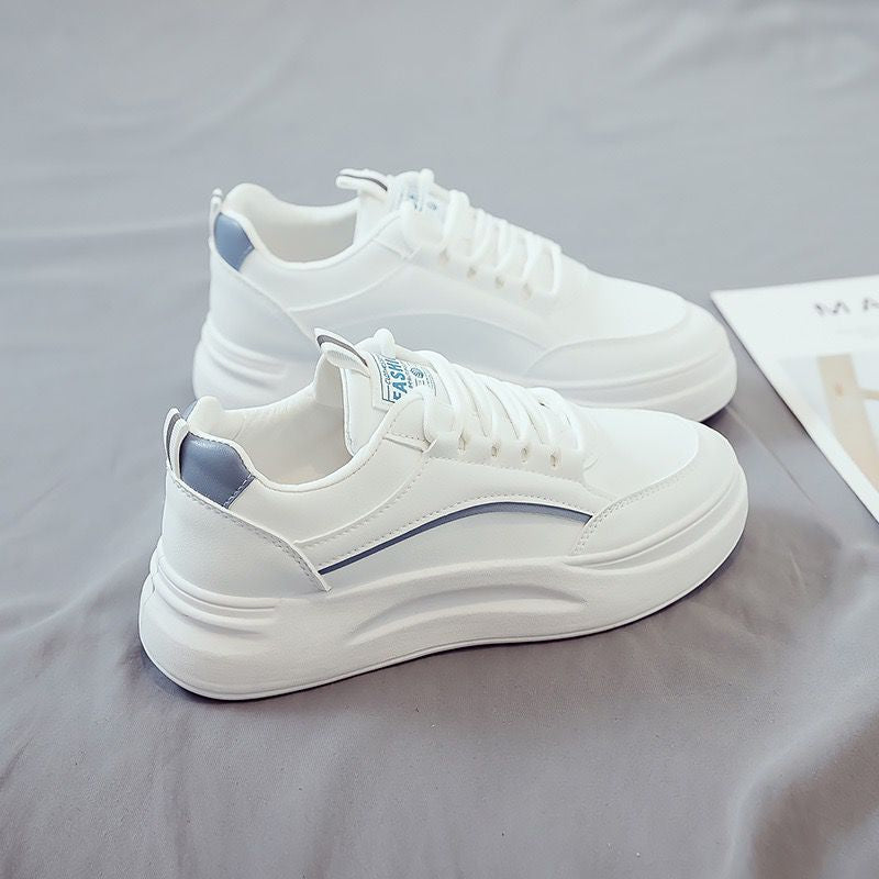 White sneakers with blue accents on a gray surface
