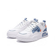 White sneakers with blue and orange accents on a gray surface