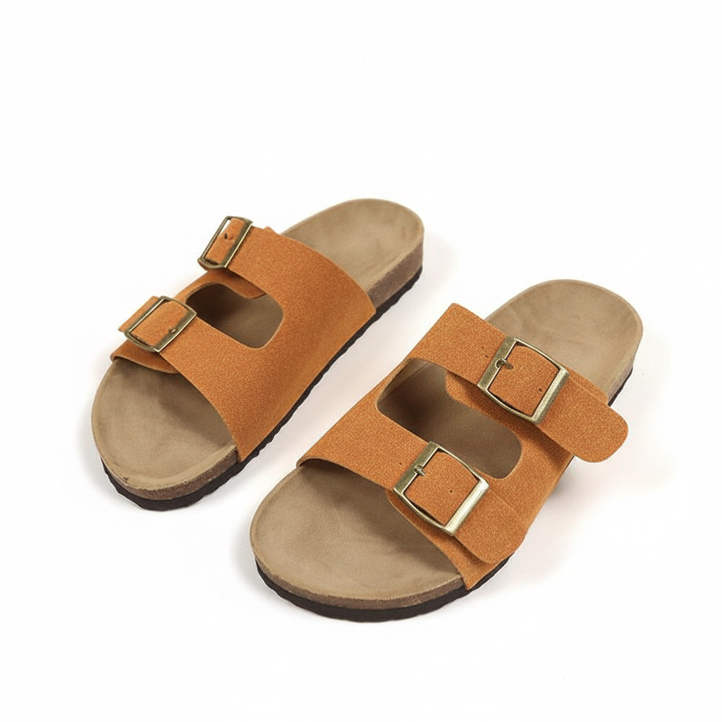 Pair of brown sandals with gold buckles on a beige background