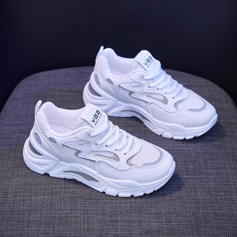 White sneakers with brand logo on a dark background