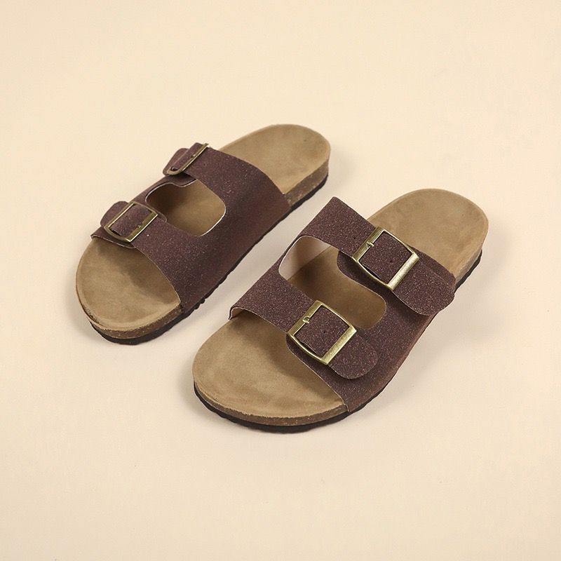 Pair of brown sandals with buckles on a beige background