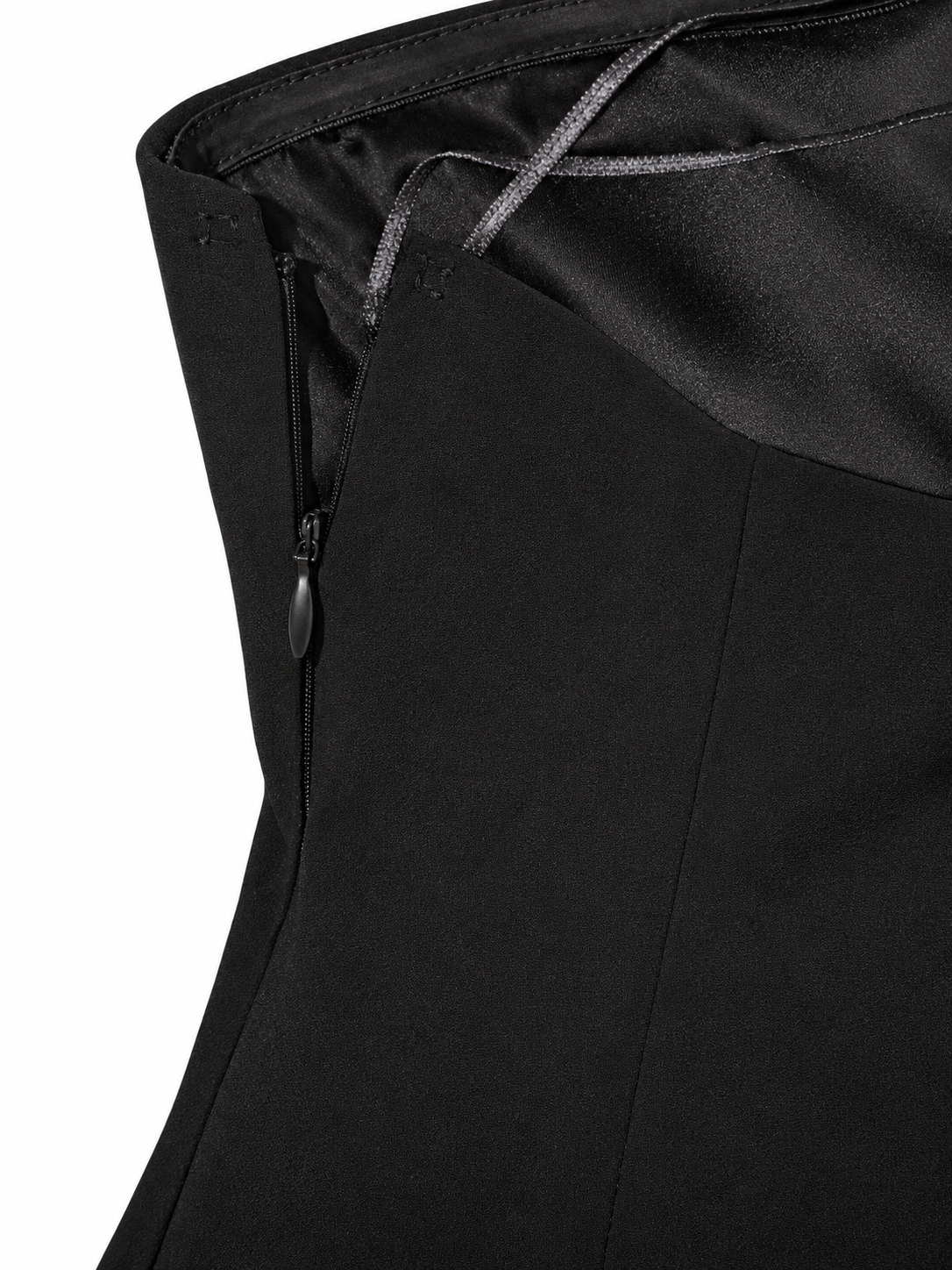Close-up of concealed zipper and inner lining on women's black strapless mini dress