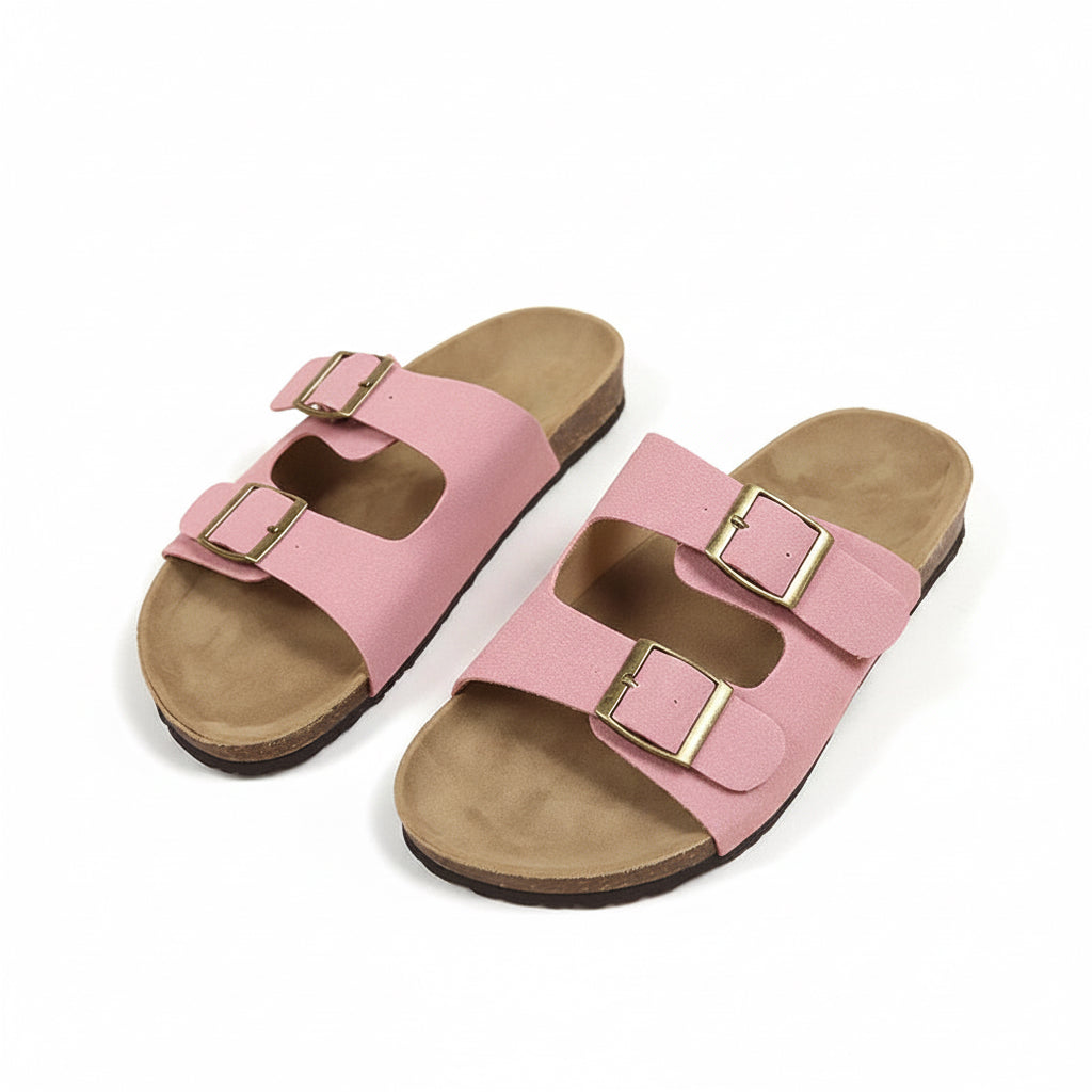 Pair of pink sandals with brown soles on a beige background