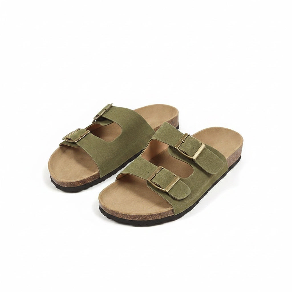 Pair of green sandals with brown soles on a beige background