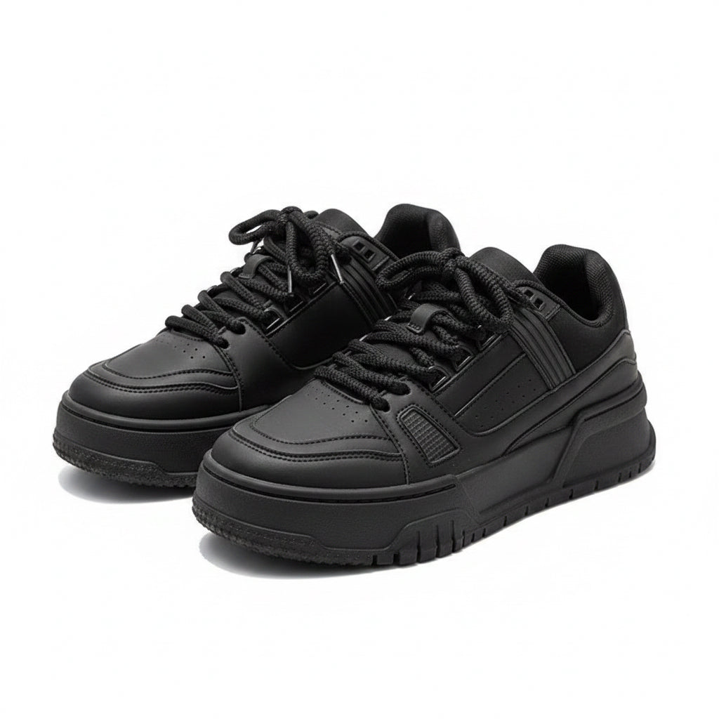 Black sneakers on a gray surface with a blurred background