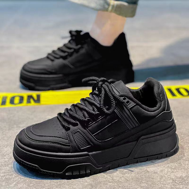 Black sneakers on a gray surface with a blurred background