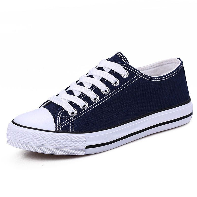 Navy blue canvas shoe with white laces on a white background
