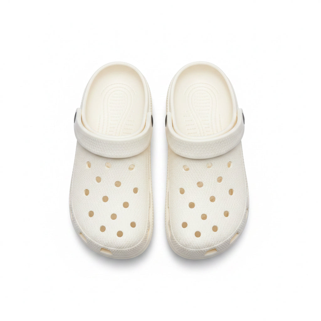 White clogs with gold polka dots on a white background