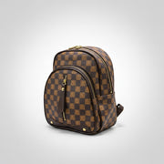 Checkered pattern backpack held by a person in a store setting with shoes and bags in the background.