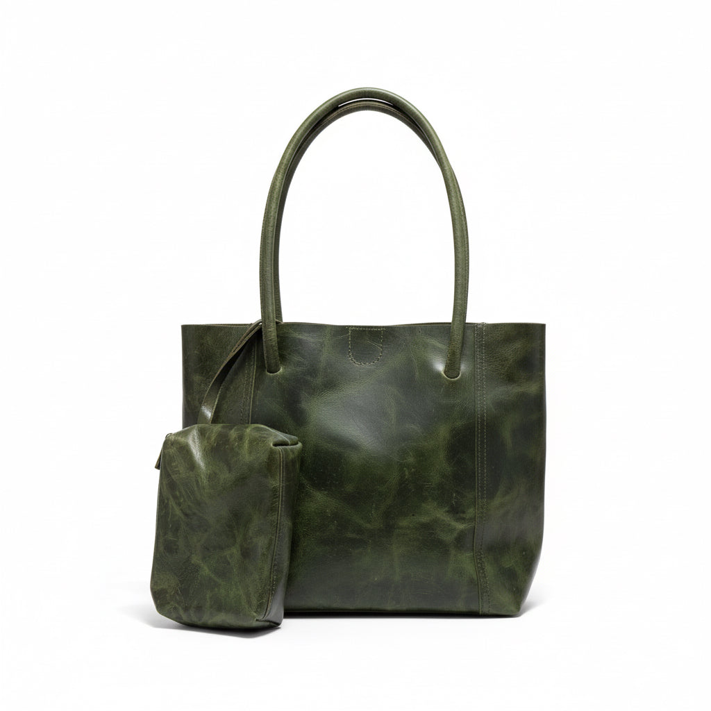 Green leather handbag on a wooden surface with a neutral background