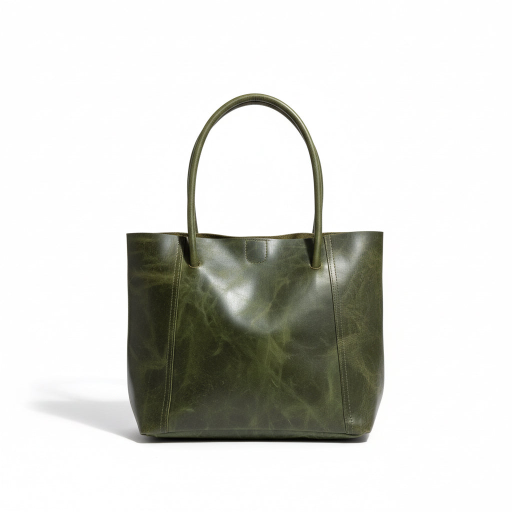 Green leather tote bag on a wooden surface with a neutral background
