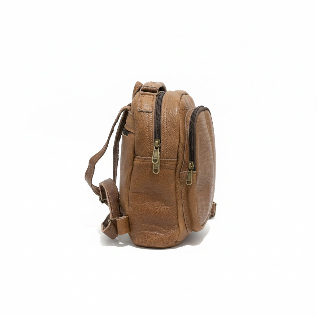 Brown backpack on a wooden surface with a laptop in the background