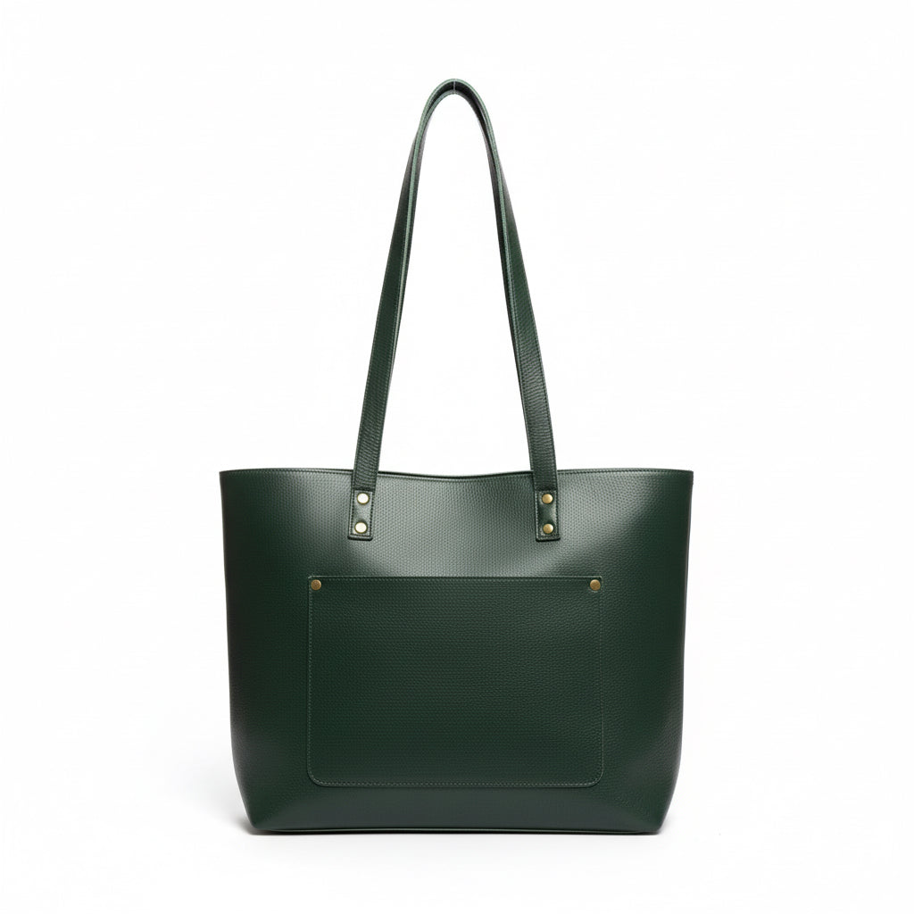 Green leather tote bag held by a hand on a light wooden surface