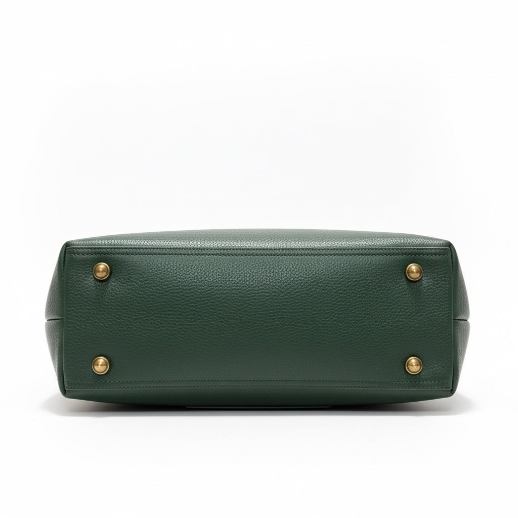 Green leather handbag on a wooden surface with a neutral background