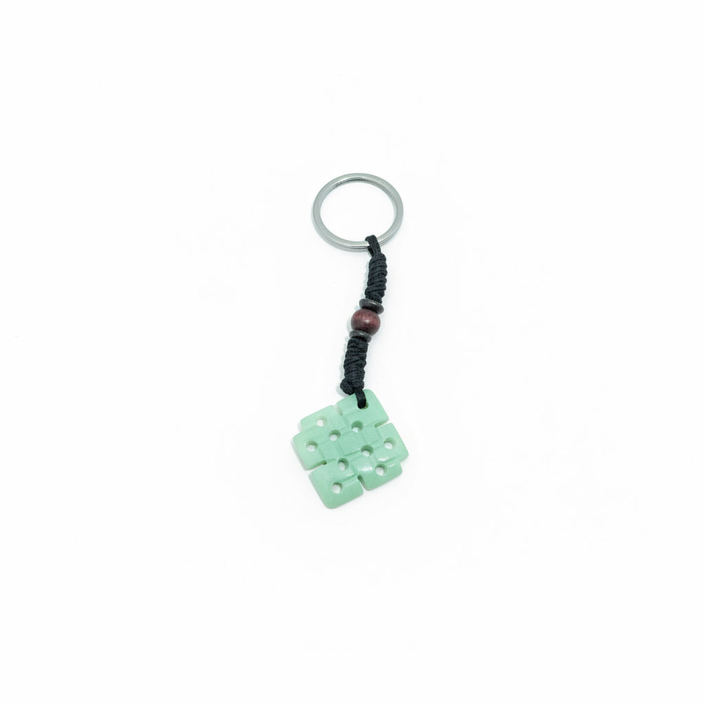 Square-shaped yak bone keychain with a hand-carved Endless Knot symbol on a black braided cord.