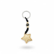 Star-shaped yak bone keychain with hand-carved border detail and black braided cord with beads.
