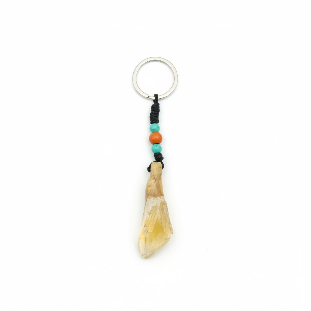 Natural weathered yak tooth keychain with orange and turquoise beads on a black cord.