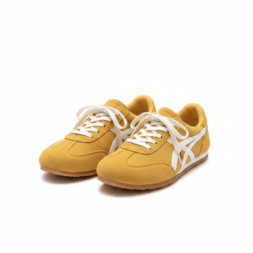 Yellow sneakers with white laces worn by a person sitting on a chair.