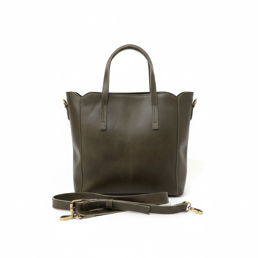Dark leather handbag with a strap on a surface