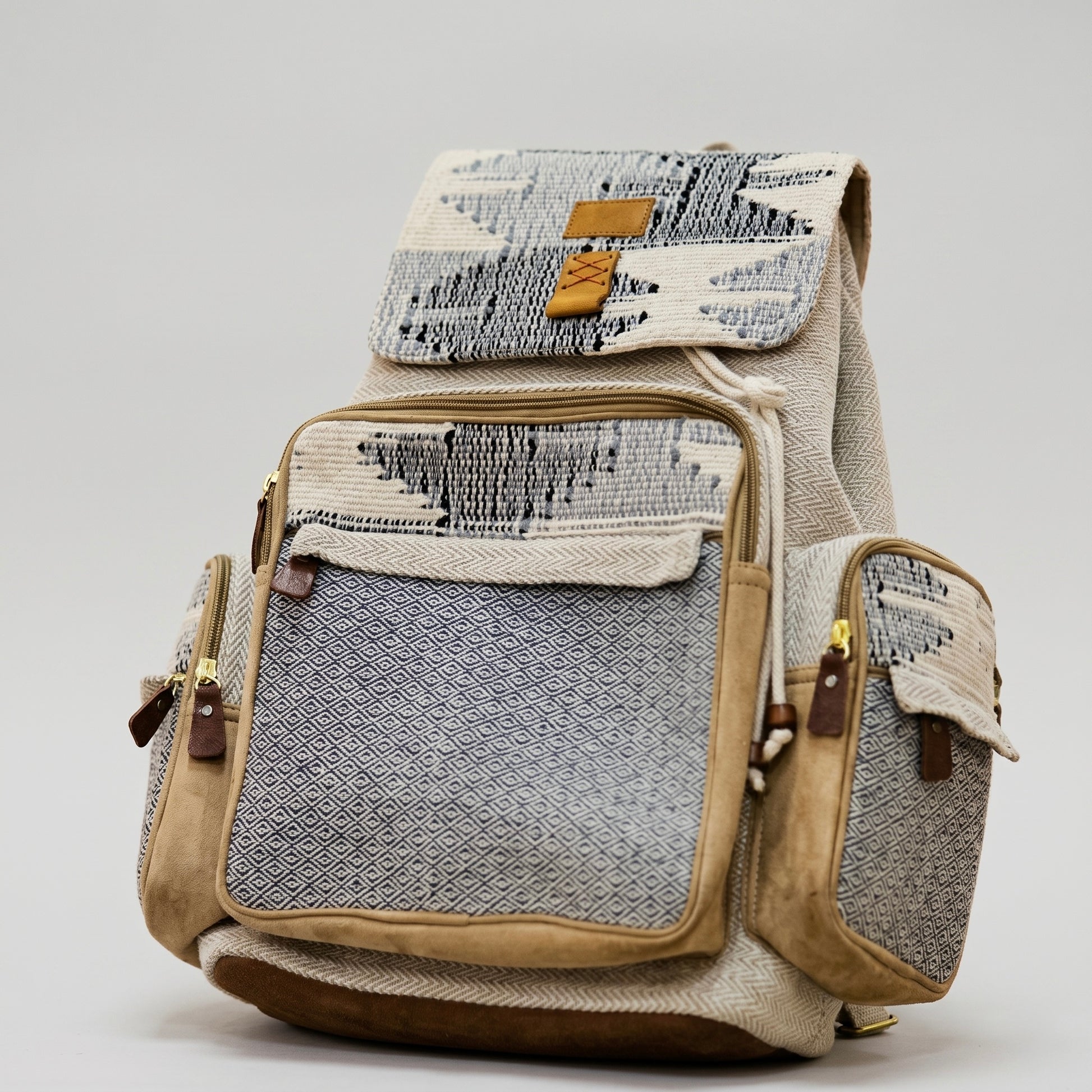 Grey geometric print backpack by ROLO, featuring tan suede trim, a front zipper pocket, side pockets, and a drawstring flap closure on a light background.
