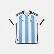 Argentina soccer jersey with light blue and white vertical stripes and dark trim details laid flat against a white background