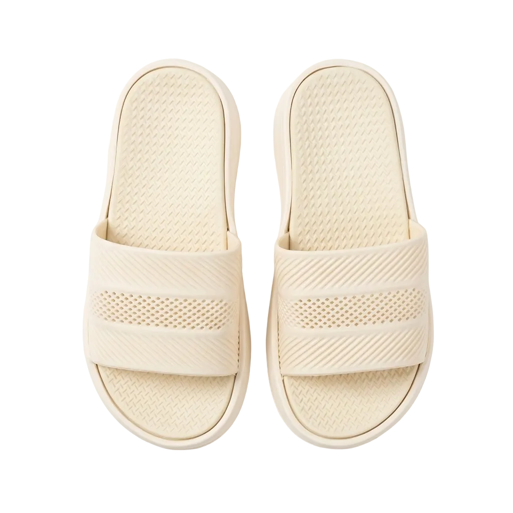A pair of light beige slide sandals with textured straps and cushioned footbeds, photographed from a top-down view on a clean white background.