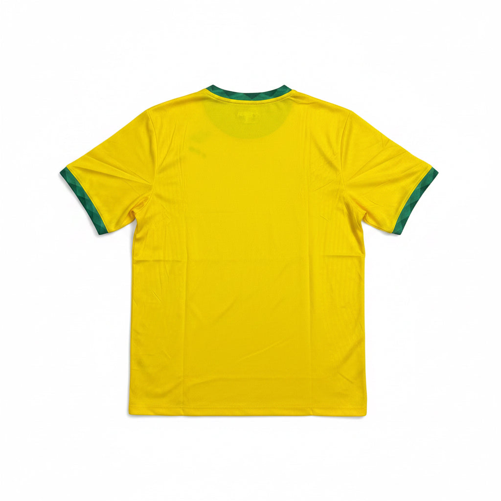 Brazil yellow soccer jersey with green trim on the collar and short sleeves laid flat against a white background