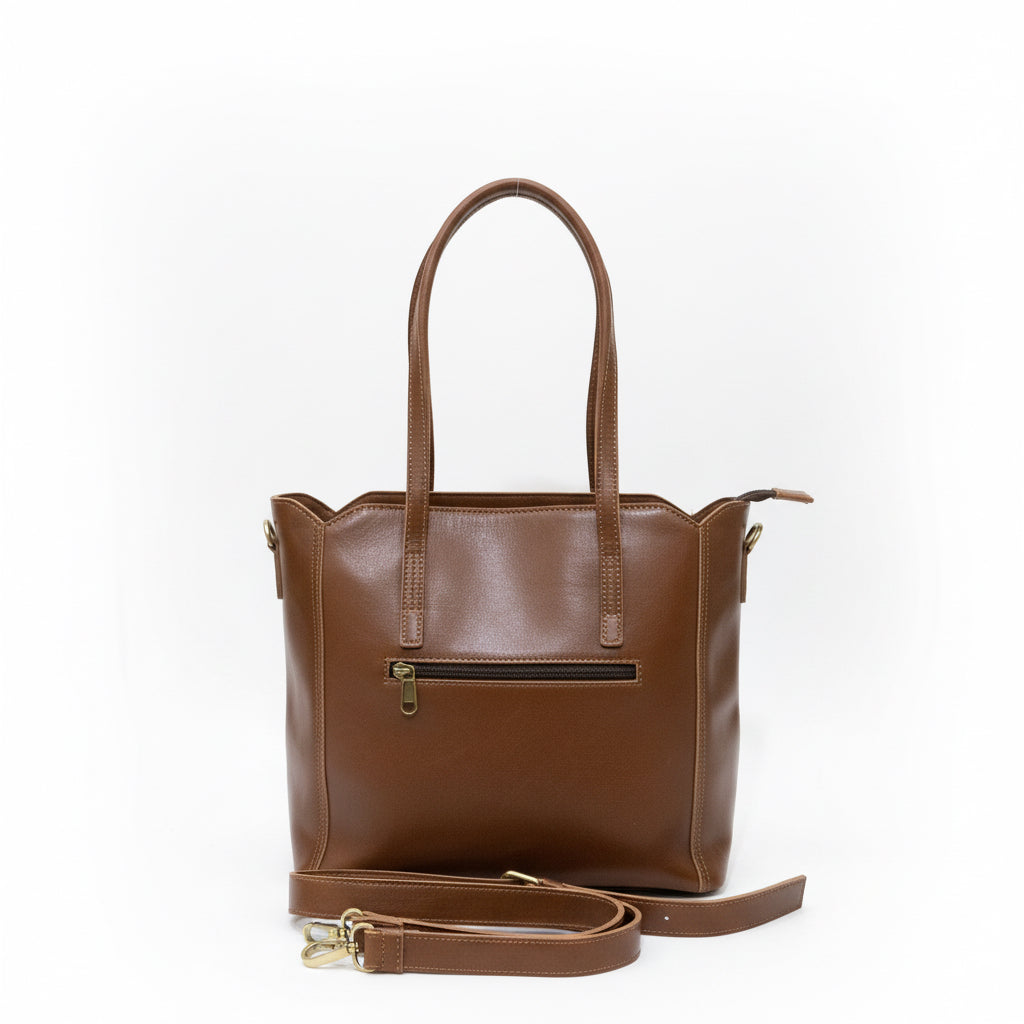 Brown leather handbag on a wooden surface next to a laptop