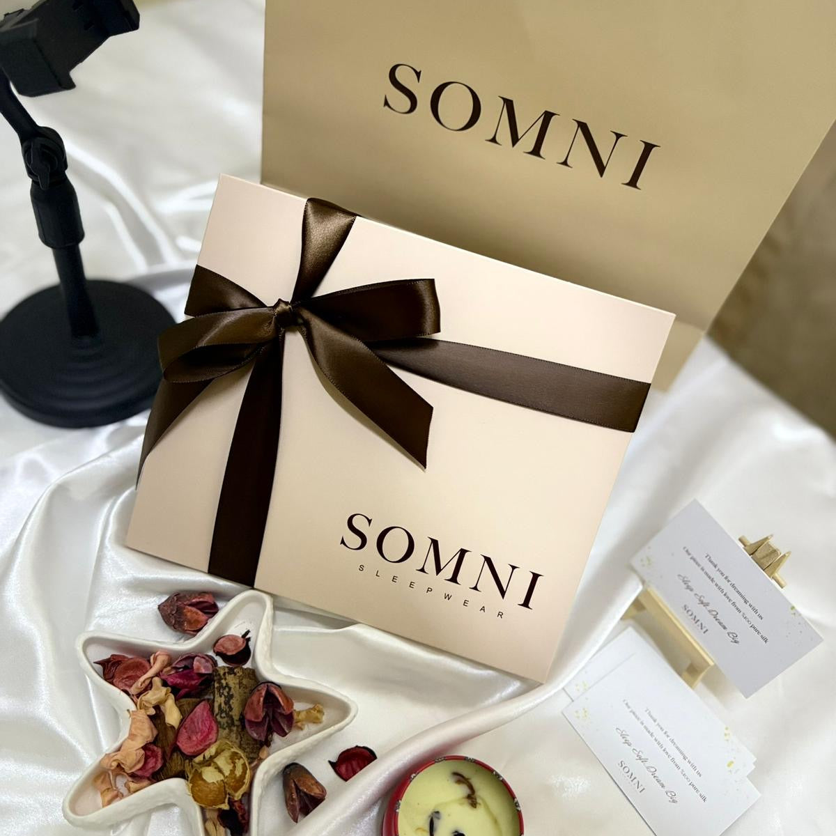 Gift box with a bow labeled 'SOMNI' on a white surface