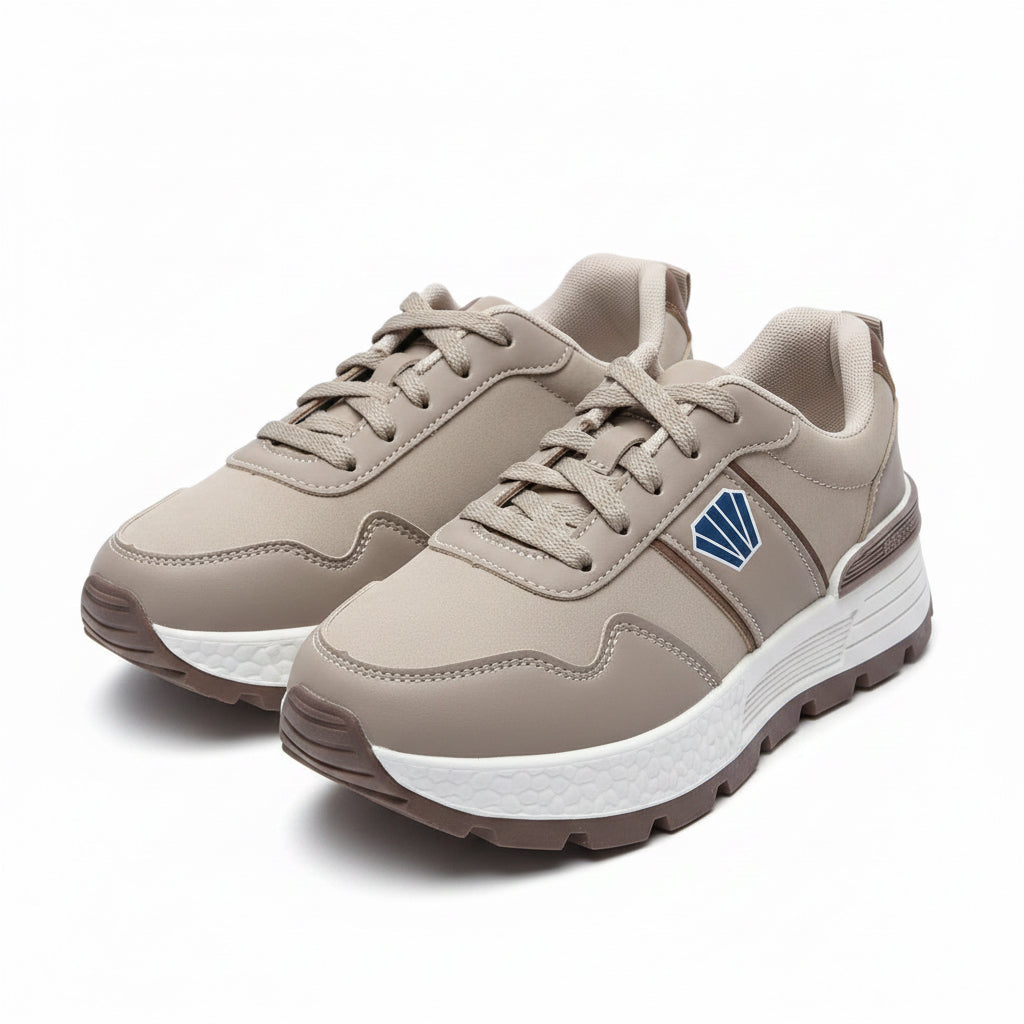 Pair of unisex light khaki sporty casual sneakers featuring a blue emblem accent and textured white midsole.