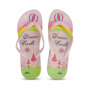 A pair of children's flip-flop sandals with a 'Dream Castle' theme. The sandals feature a light pink upper and sole, decorated with a colorful rainbow, hot air balloon, castle, and green grassy base.
