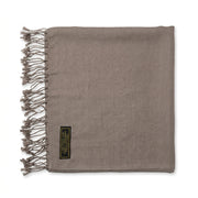 A taupe brown woven scarf with fringed edges and a small black brand label, laid flat on a white background.