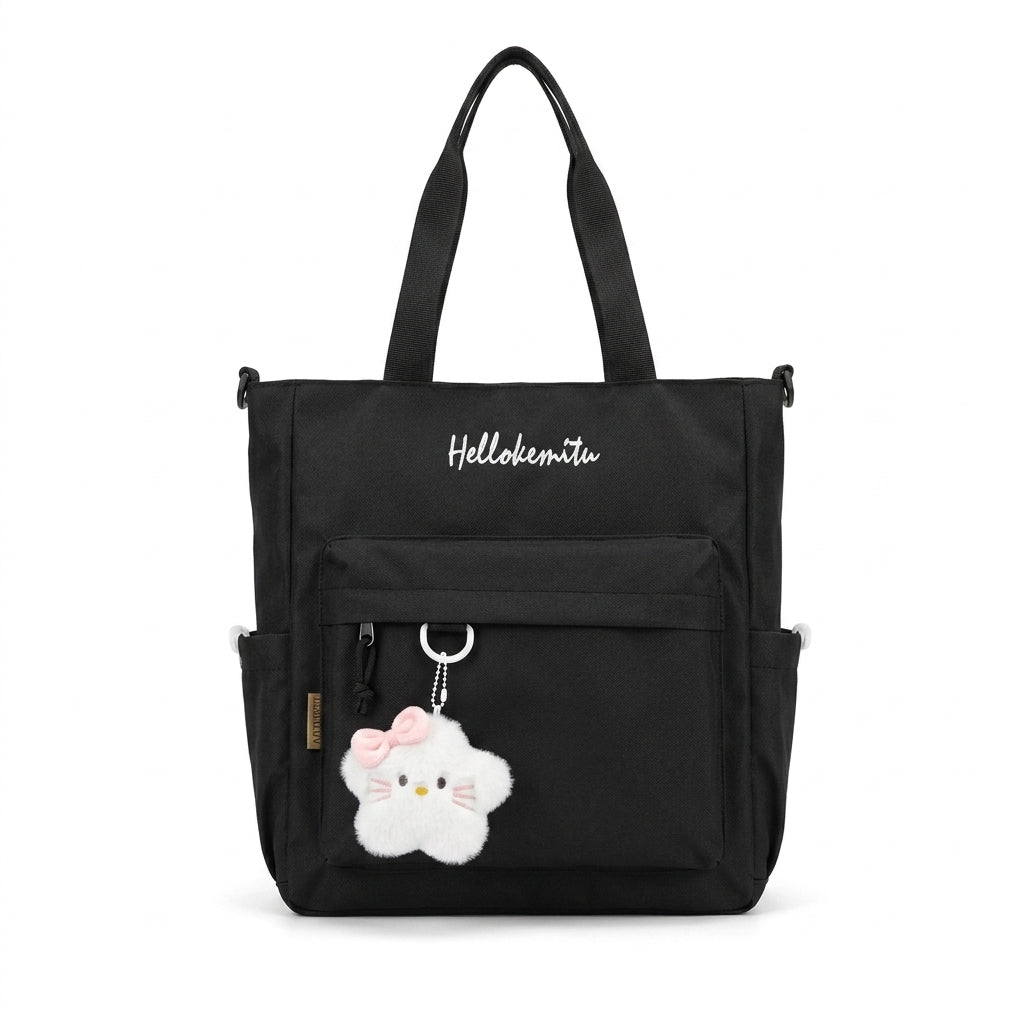 Black Hellokemitu canvas tote bag with embroidered front text, zippered front pocket, and plush character keychain charm