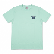 A mint green crewneck t-shirt with a small dark blue-green shield-shaped patch on the left chest containing the text 'John Deere'. The shirt is laid flat against a clean white background.