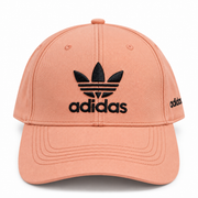Peach baseball cap with black embroidered logo-style graphic and curved brim