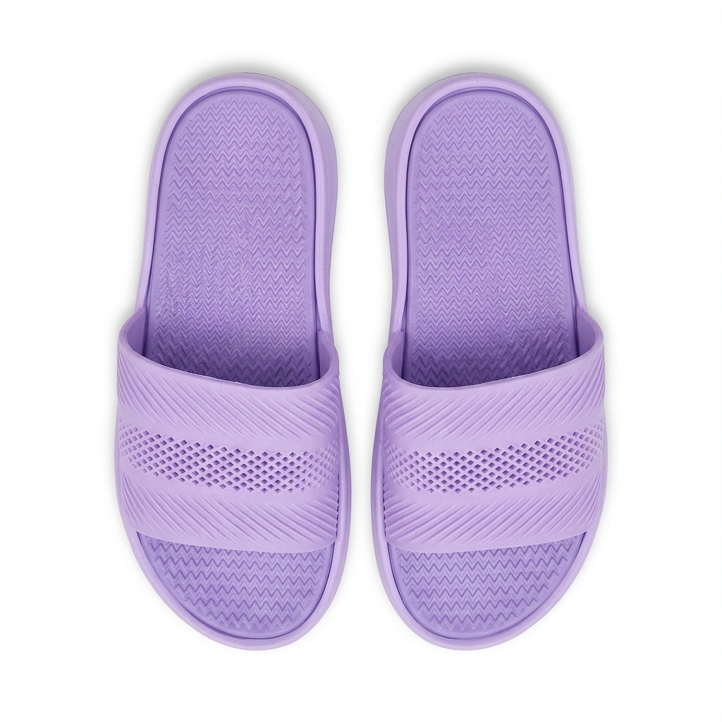 A pair of lavender purple slide sandals with textured straps and footbeds, shown from a top-down view on a white background.
