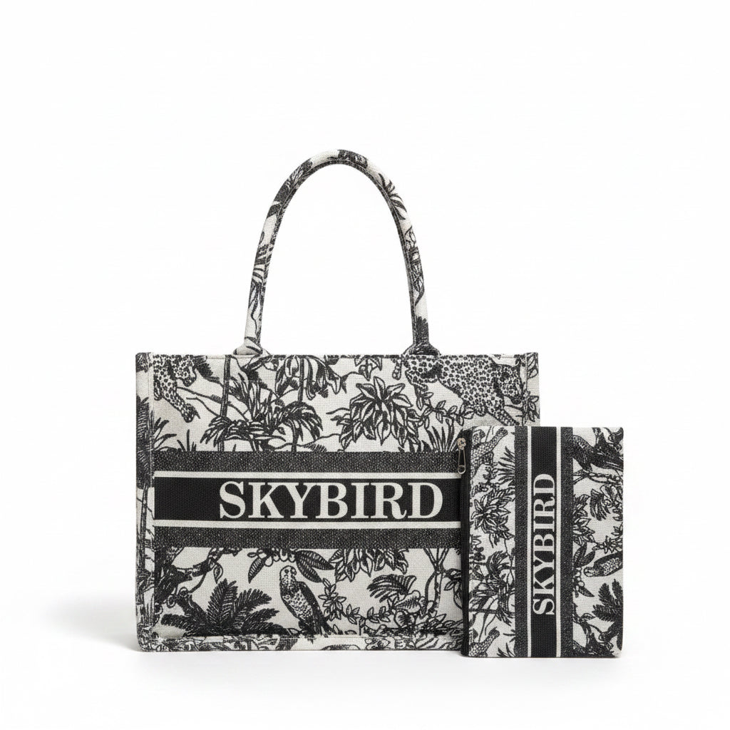 Two-piece SANBA COLLECTION Skybird bag set featuring a black and white tropical palm tree print on a canvas tote and matching zippered pouch.