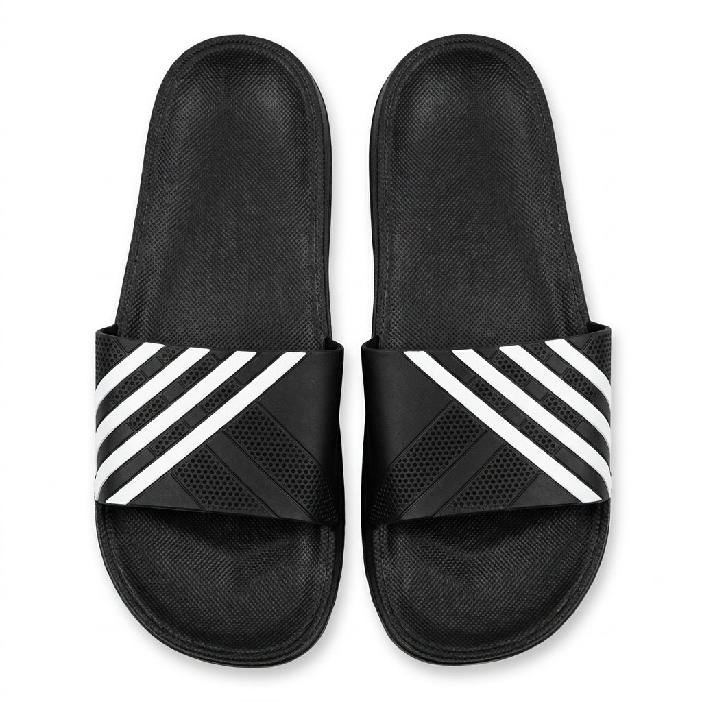 Pair of black casual slide sandals with white diagonal striped strap top view